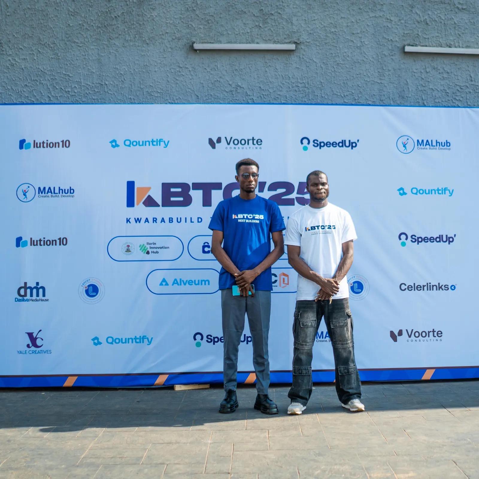 Kwarabuild team members standing in front of the KBTC25 partner wall
